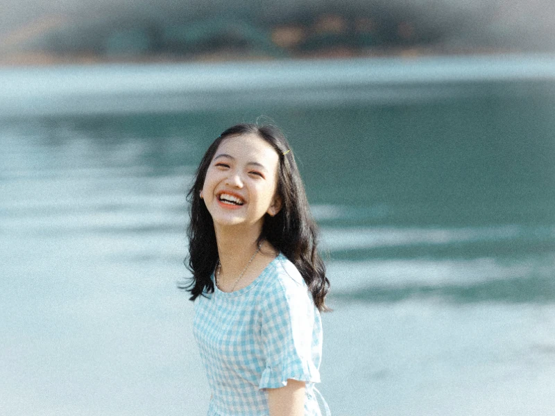 Smiling teenage by the lake, at Turning Winds, embodying happiness and tranquility after treatment for anxiety in teens