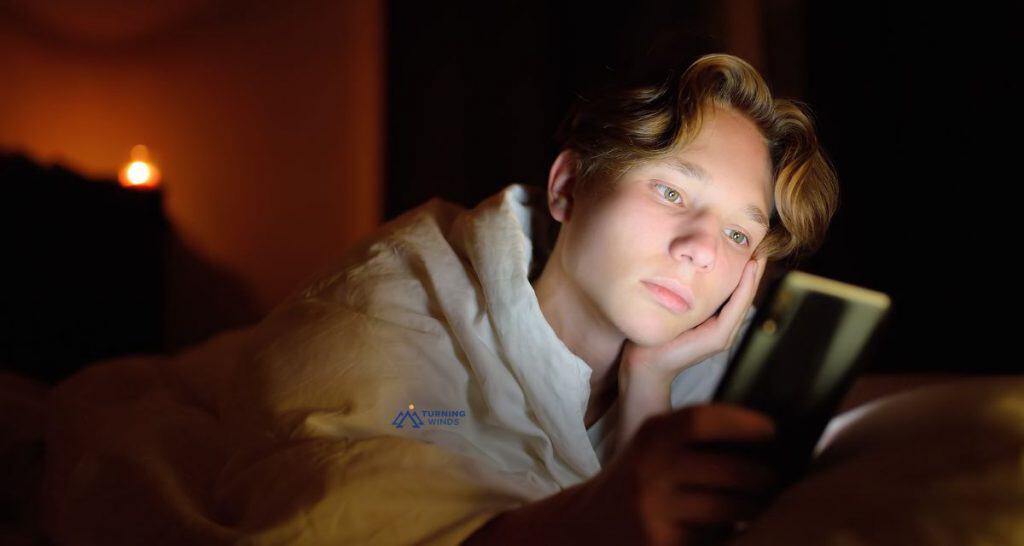 Teen lying in bed looking at a smartphone, watching YouTube -- struggling to sleep. 